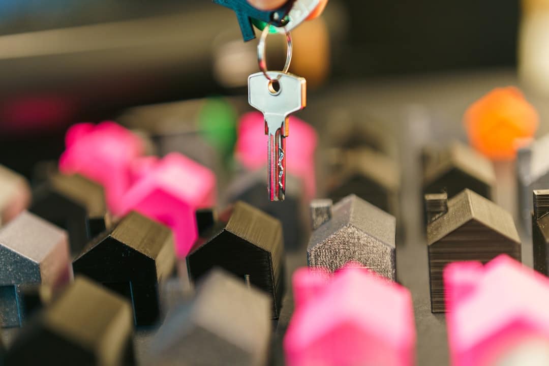 A modern house key resting next to a clean, white piggy bank on a bright surface, symbolizing saving home equity when selling a property.