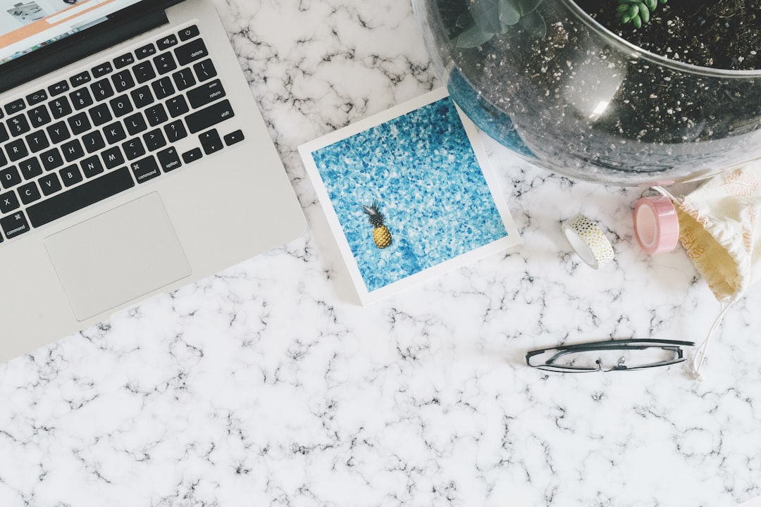 A clean, minimalist desk features a laptop and a set of house keys, symbolizing an efficient and uncluttered approach to real estate services.
