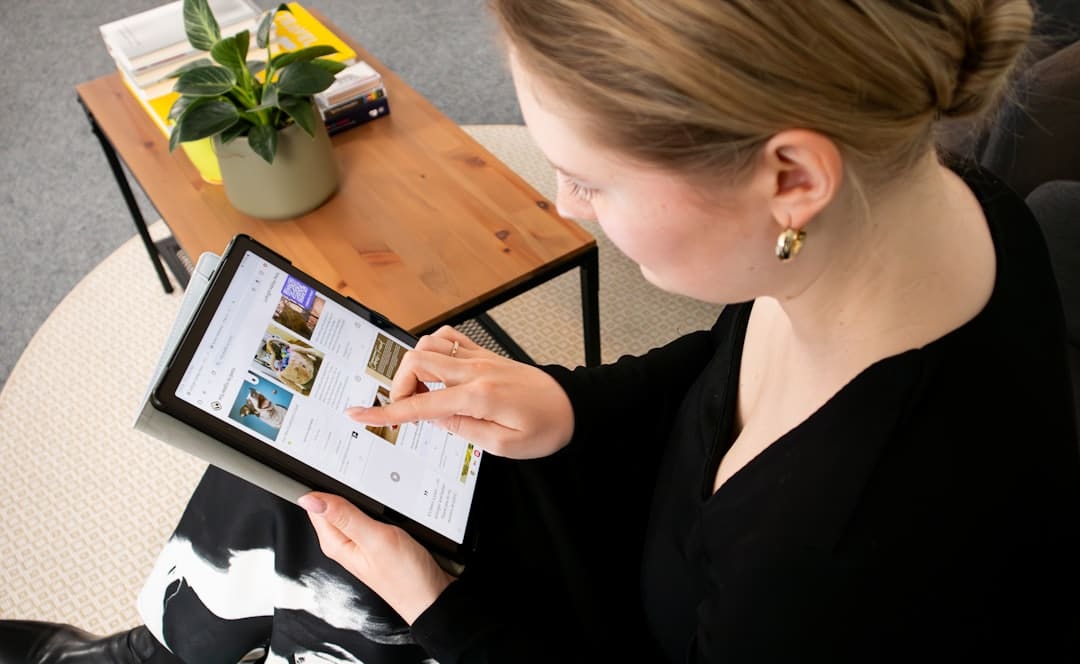 Professional real estate agent stands in a bright, modern home, using a tablet to showcase a streamlined, tech-enabled pro...