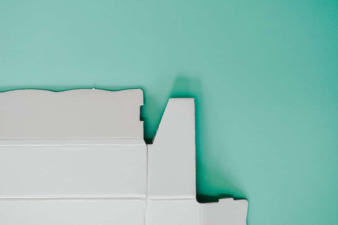 A homeowner carefully painting an interior wall in a bright, modern room, symbolizing the reinvestment of commission savings to increase a home's value.