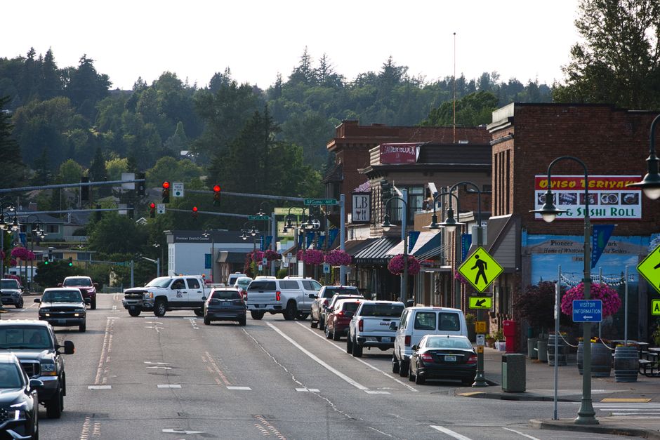 Bright, sunny day on a charming main street filled with people walking and visiting local shops, representing a thriving l...