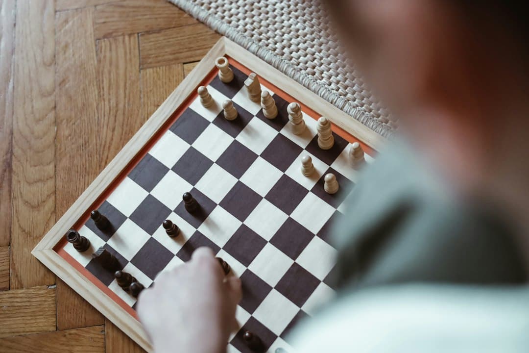 A macro shot of a hand strategically moving a chess piece on a board, representing the tactical advantage and smart negotiation in a real estate deal.