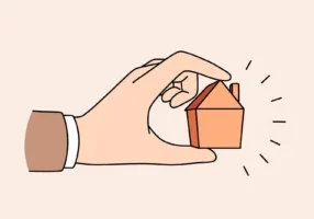 Human hand holding little tine house