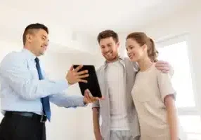 Mortgage--people-and-real-estate-concept---happy-couple-and-realtor-with-tablet-pc-computer-at-new-home--couple-and-realto...