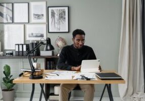 Professional real estate agent in a bright, modern kitchen, using a digital tablet to manage a property listing, illustrat...